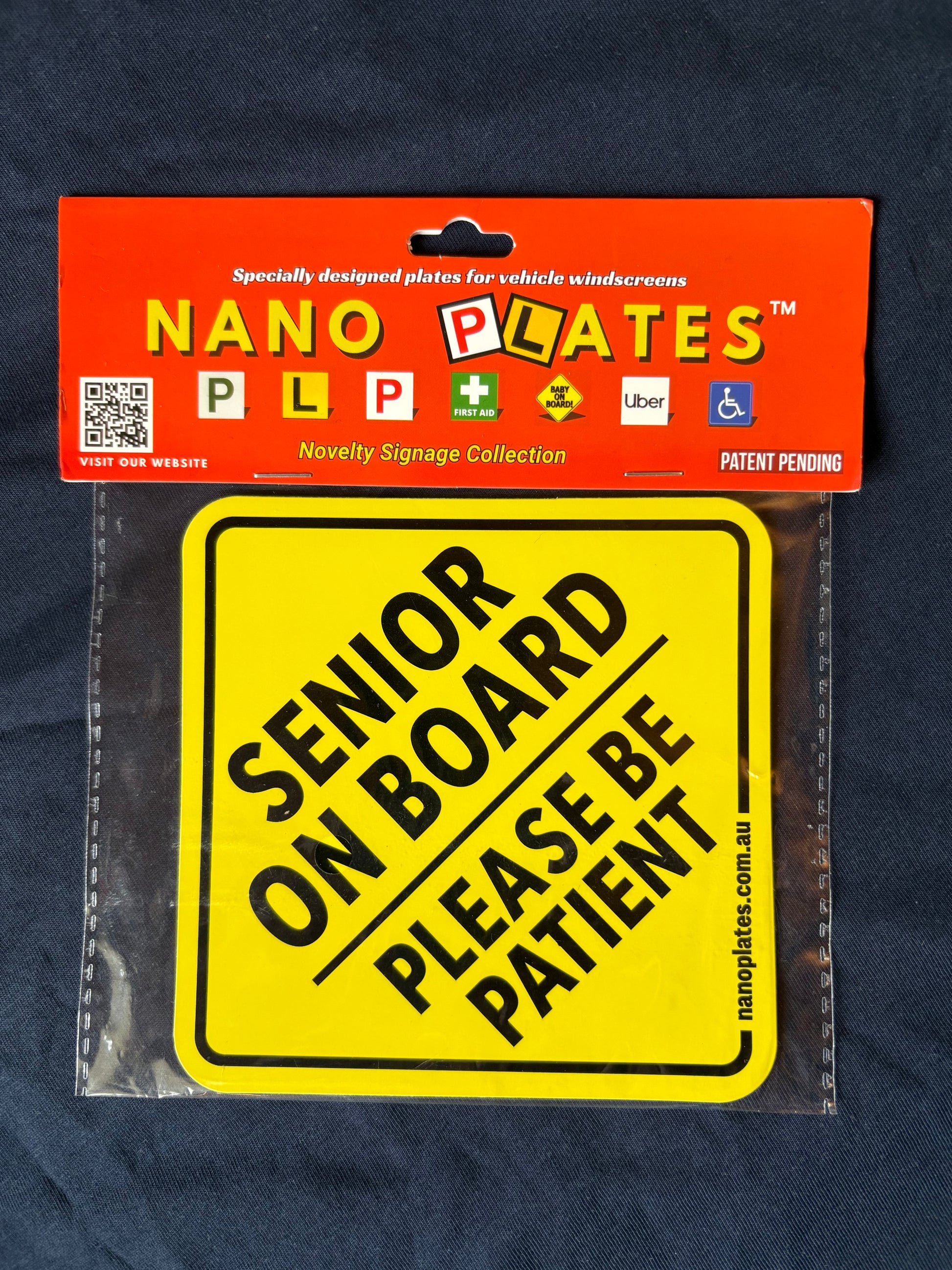 Yellow 'Senior on Board Please Be Patient' sign in packaging with Nano Plates branding.