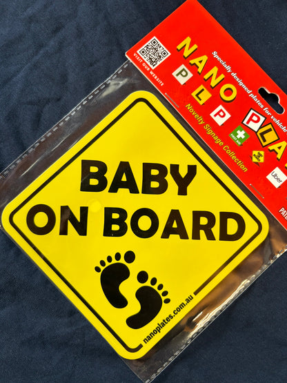 Yellow 'Baby on Board' sign with black text and footprints, in clear packaging with a nanoplates label.
